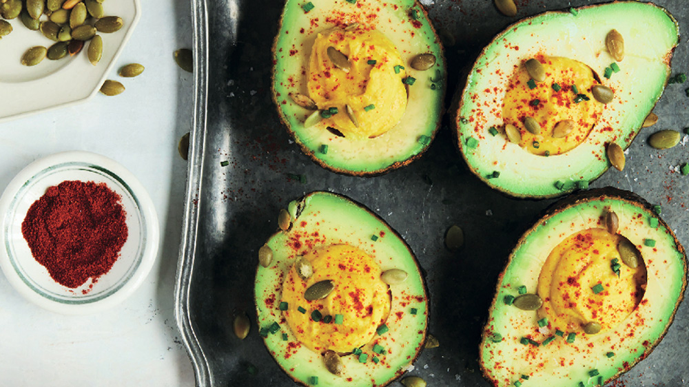 Healthy devilled avocado with squash seeds