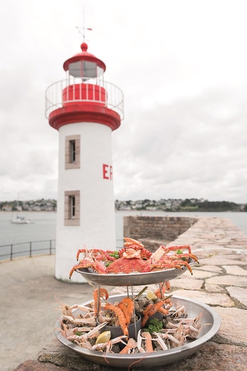 Lighthouse with seafood in front of it
