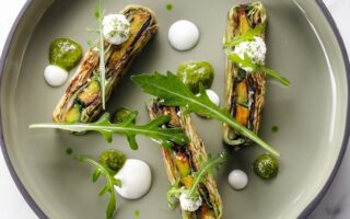 Layered arugula pistou, pointed cabbage, and grilled avocado