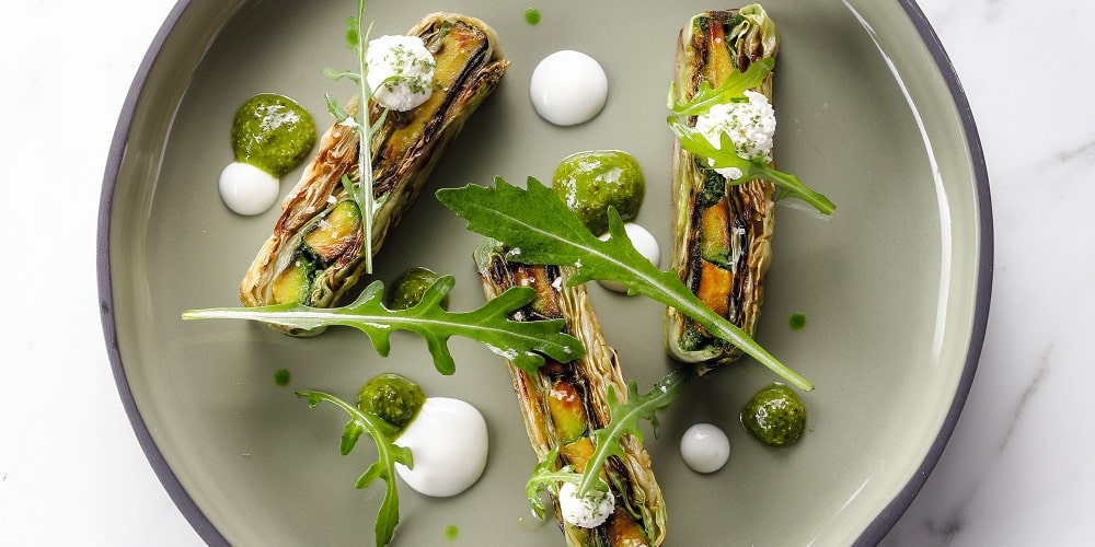 Layered arugula pistou, pointed cabbage, and grilled avocado