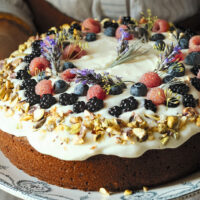 Frosted Pistachio Cake topped with berries and lavender