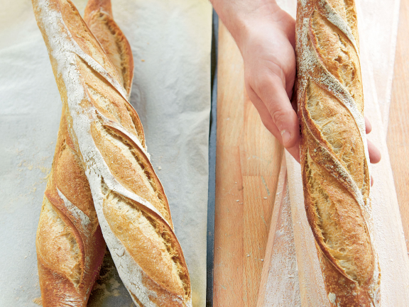 A baker with a french baguette in his hand